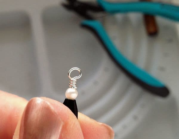 The wire wrapped loop with the trimmed end tucked in and the wrapped section of wire rounded with the crimping pliers