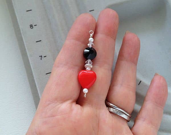 By rotating the "eye" at the bottom of the eye pin 90 degrees, the loops at the tops of the upper and lower dangle sections will face the same direction in the assembled earring.