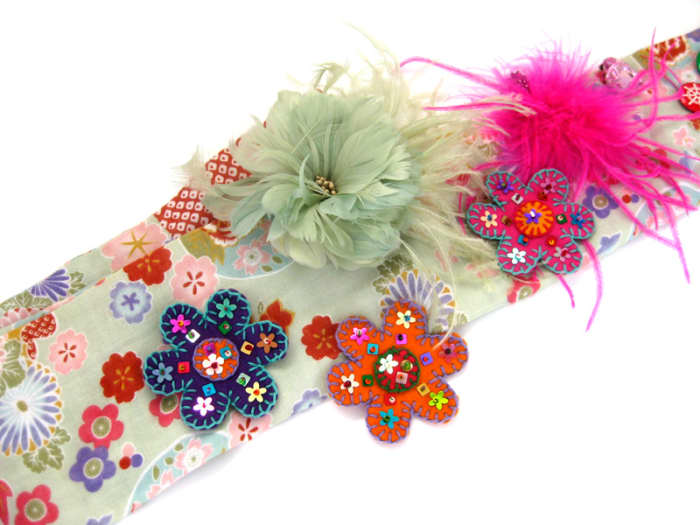 Adding felted flowers to a scarf, along with colourful fascinators. Wear something like this to advertise your wares when selling with a basket.