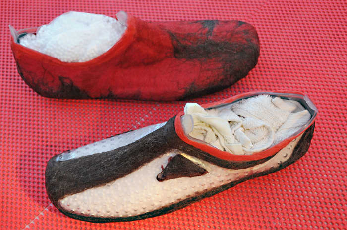 Here one layer has been completed and one has not. The logo is seen face down on the Aqua shoe. When the shoe is removed and the slipper has been turned inside out, itt will be facing right side up. Decoration is done on the reverse side.