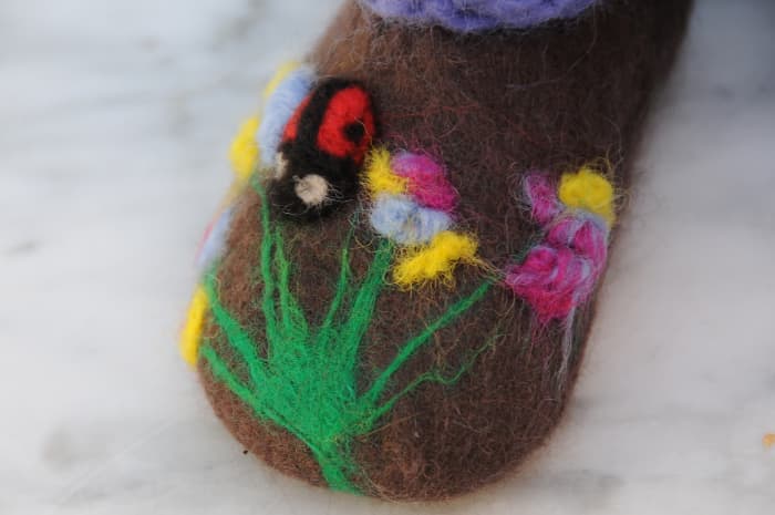 Needle felt any loose bits of wool to the slipper and add a little ladybird using black, red and white merino wool roving.