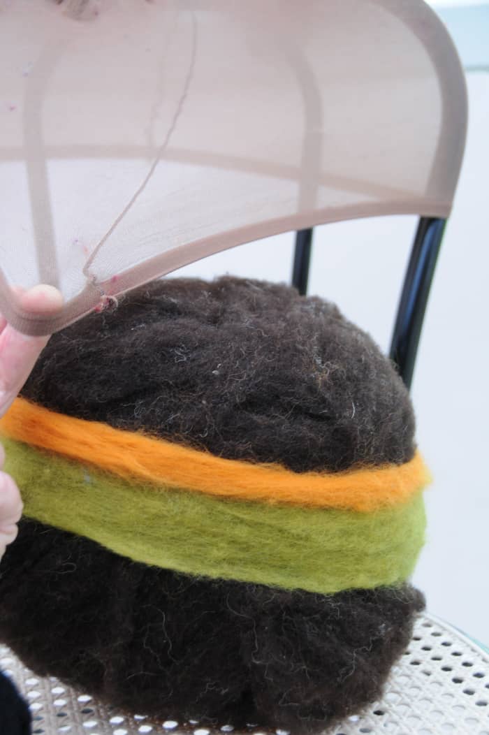 Put the wool covered ball on a chair as shown and lift the ball up into the stocking as shown.