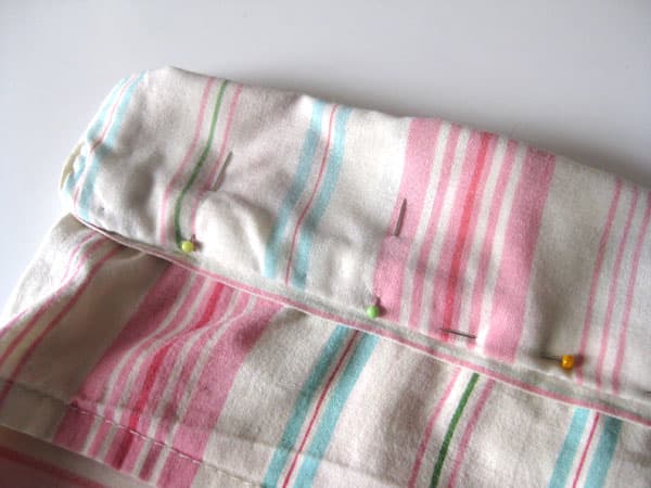 The vertical pins indicate where to start and stop sewing, leaving an opening where the drawstring will go.