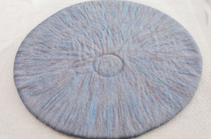 Mark a small circle in the wool with a small round object, about three inches in diameter. I used a roll of masking tape to press the circle.