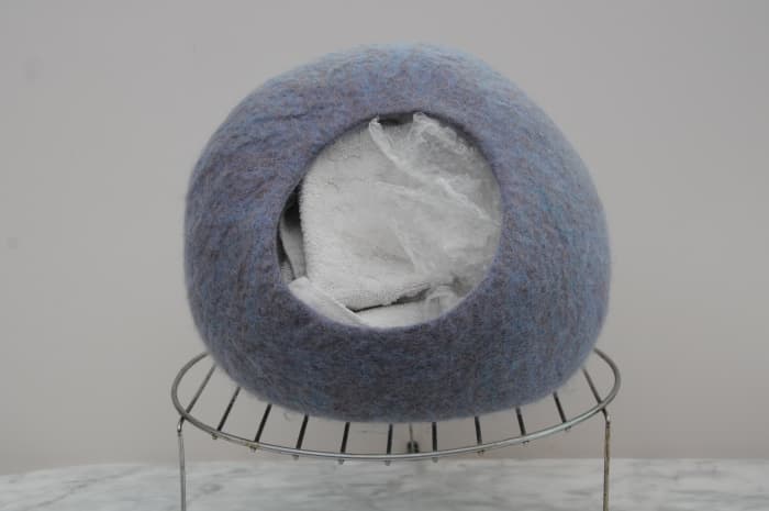 This cat cave is stuffed with towels and bubble wrap, left to shape and dry on a cake rack. Remove the towels and bubble wrap when it can be seen that the shape will be maintained.