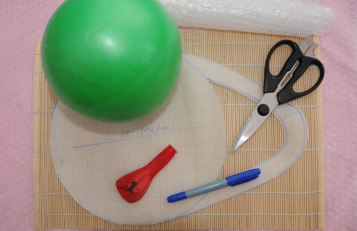 Gertie ball, balloon, scissors, felt tip pen and the template which has been cut out.