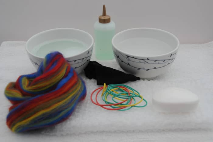 Items required to wet felt a bar of soap, wool roving, hot soapy water elastic bands, piece of bubble-wrap, piece of cut off tights.