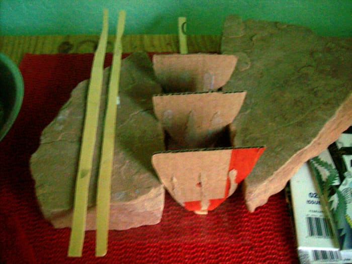 The partitions of a ship wedged between pieces of flagstone. The lumber or timbers for the sides of the hull are to the left.