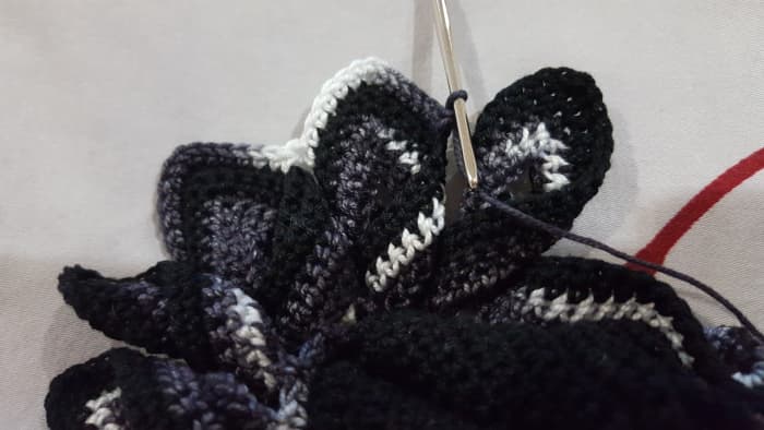 The point on the left of the middle point (where the hook is resting) is the point where the ends are overlapping together. The one to the right of the hook is already twisted and ready for the next set of stitches.