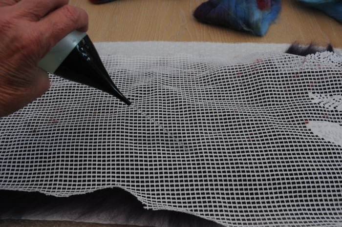 Cover with curtain netting. Wet and smooth down the fibers. Remove the netting and turn the project over.