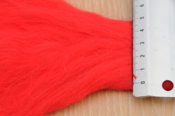 The roving which was only 5 cm across should be opened up to measure around 13/14 cm to form a flat even piece of woolen fibers.
