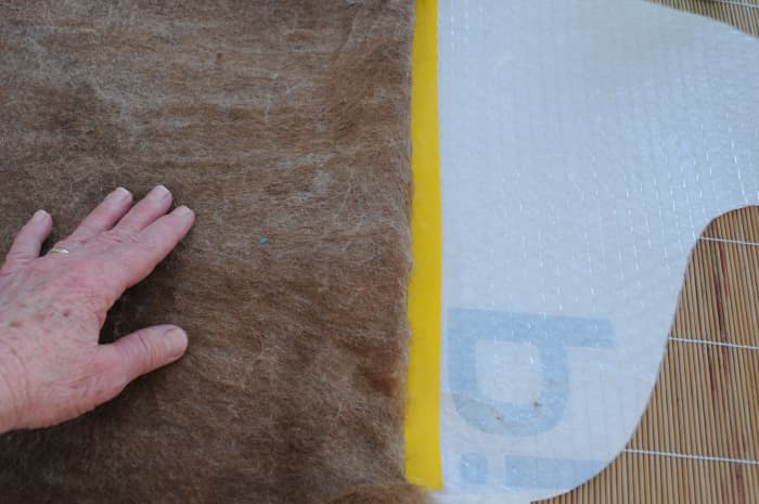 Turn the top edge over and form a straight line across the taped edge of the template.