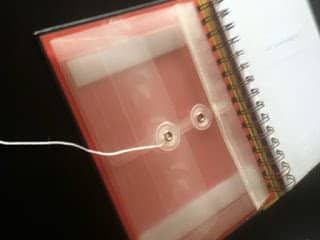 If you don't have a plastic envelope, you can use a paper envelope instead. Instead of using the velcro-tape to affix the envelope, use clear white glue.