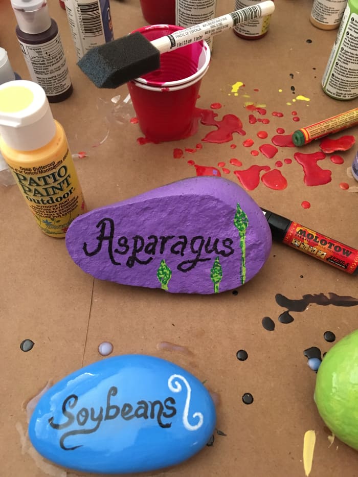 "Soybean" and "Asparagus" plant markers. I painted little asparagus shoots emerging from the lower edge of the stone's face. I didn't know what a soybean looks like, so I drew a flourish instead.
