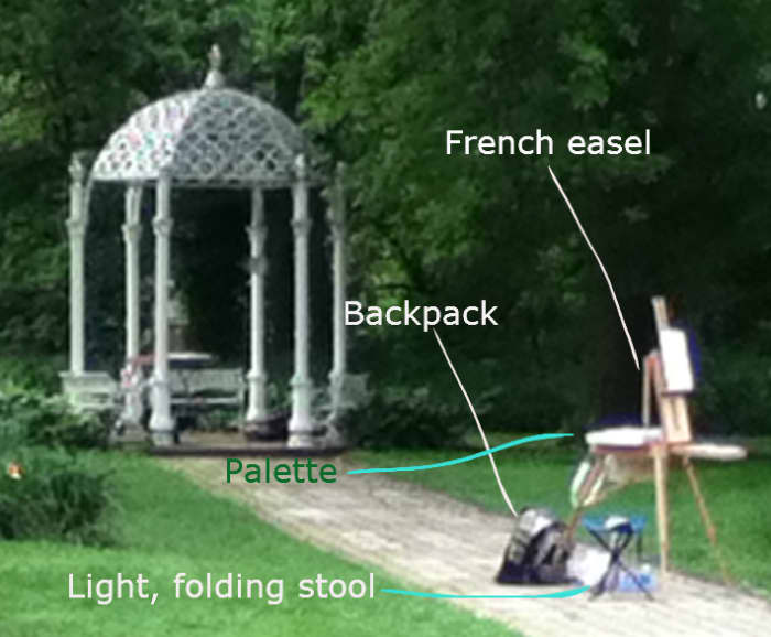A photo of the setup of a fellow artist before she got started painting. Notice how she had a French easel, a backpack to carry her materials, a flat palette, and a light foldable stool.