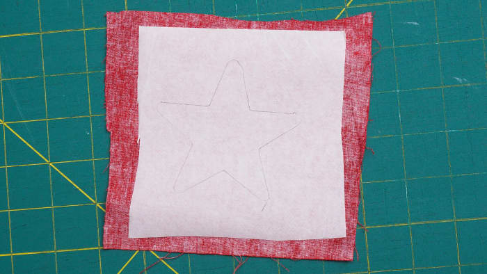 Using your star template, trace the shape onto the paper side of the fusible web that has already been placed on the fabric.