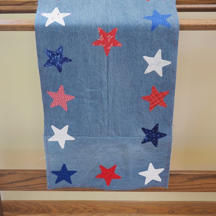 This patriotic table runner made from repurposed blue jeans and fabric scraps doesn't just have to be displayed on a table. Hang it over a quilt rack for added color.