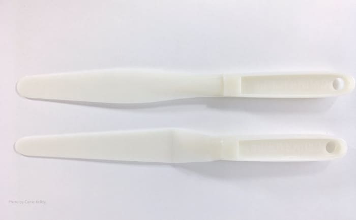 These two plastic palette knives from a Grumbacher palette and painting knife set are about 10" long and made from a durable plastic that's easy to clean.