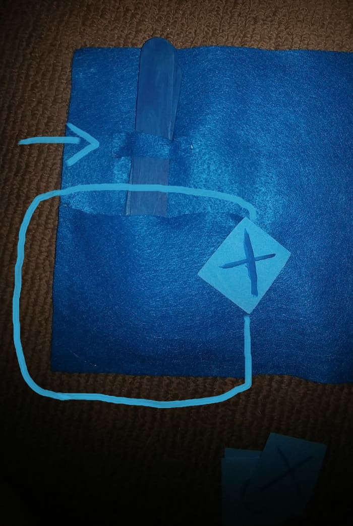 Hot glue a little strip of felt, and a small square of felt onto the felt sheet. Then the lollipop sticks and squares can be kept inside.