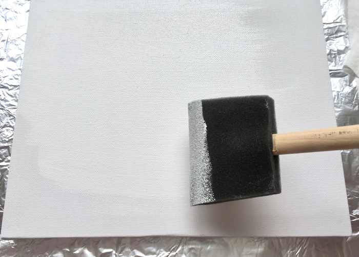 Applying a coat of gesso with a sponge brush
