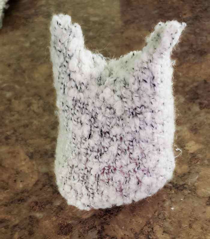 Flip your plushie over and glue buttons on to create eyes. Use a black Sharpie to make a mouth and a pink Sharpie to create cheeks.