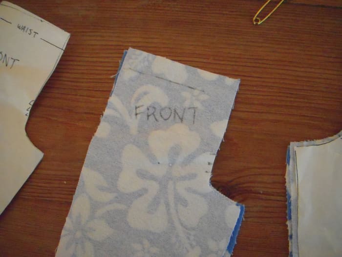 Important markings are transferred from the pattern onto the wrong side of fabric. Here, the waistline and center line markings are transferred to the fabric.