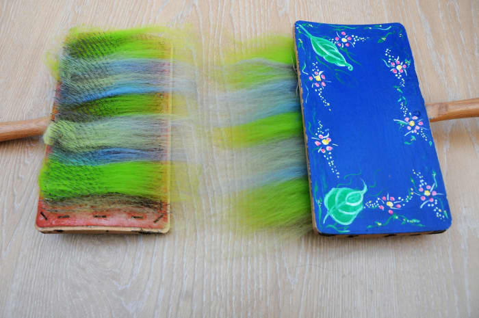 Comb the fibres starting at the bottom of the left hand carder and gradually work up the carder.