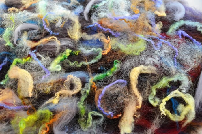 Create a thick layer of wool roving on the top of each hat template and cover with embellishment.