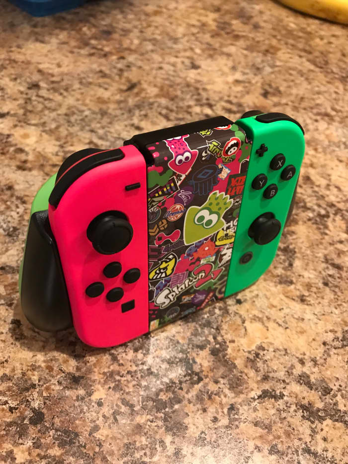 The "Splatoon 2" PowerA Comfort Grip for Nintendo Switch with the "Splatoon 2" pink and green Joy-Cons.