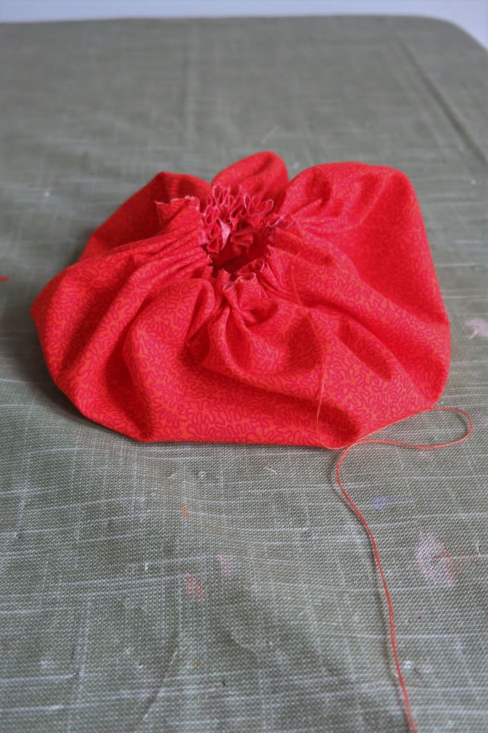 Make a running stitch around the circumference of the circle, then gather the fabric into a pouch.