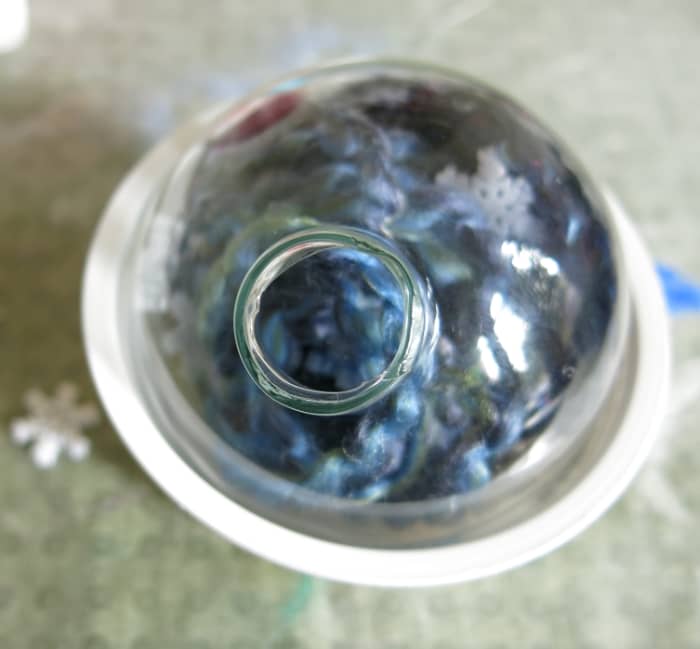 Use a small cup to hold your ornament while working and turn it to drop little items in to accessorize your decoration.
