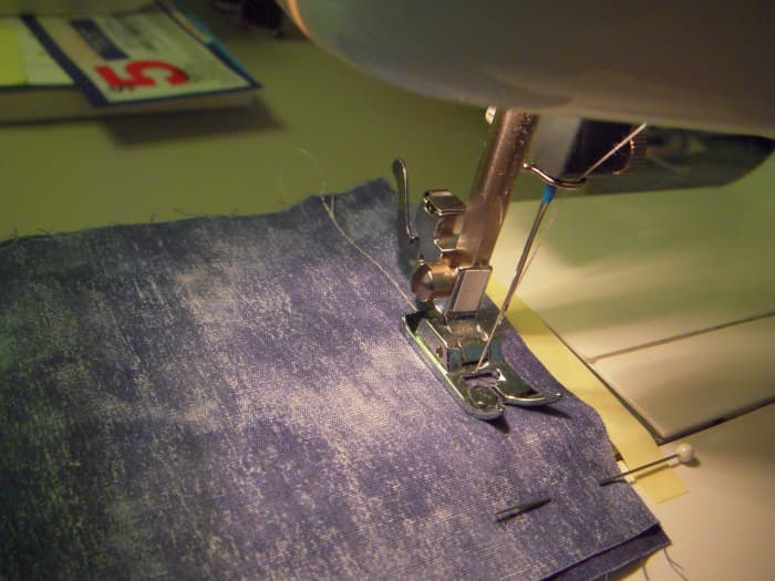 Sew the seam, guide with your left hand, but remember that the feed plate will push your fabric in the right direction (from front to back.)