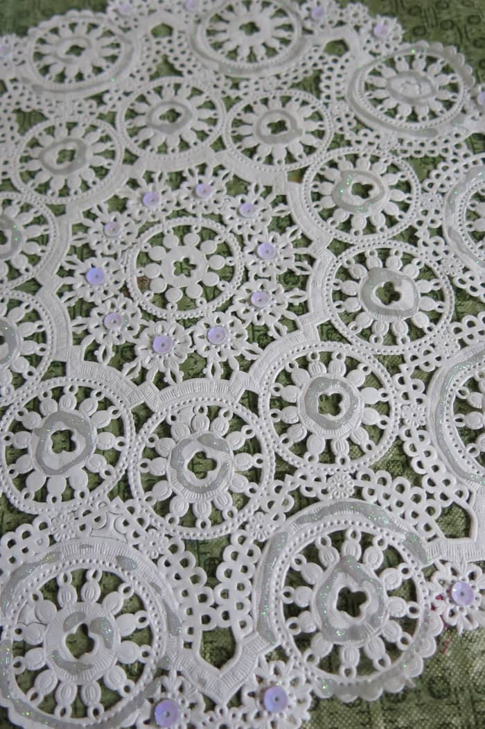 Decorate you paper doily with glitter and sequin to add some sparkle to your paper angel.