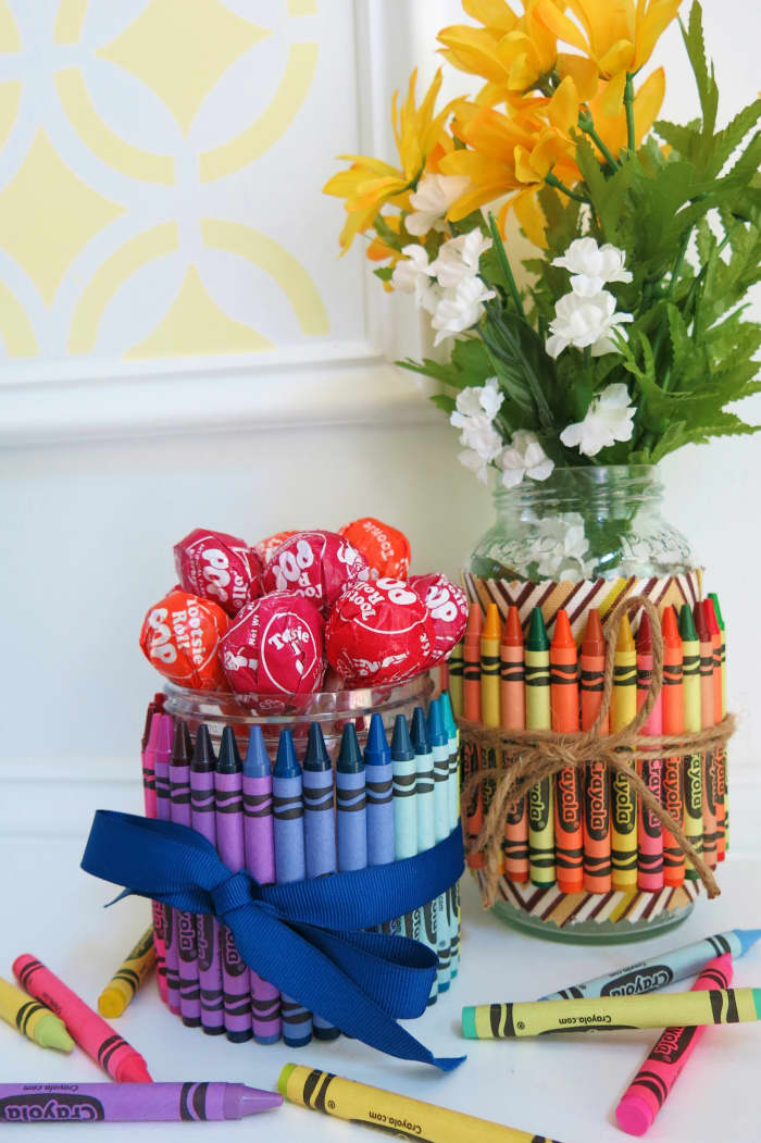 These crayon covered jars can be filled with flowers, candy, or art supplies to make the perfect gift or decoration.