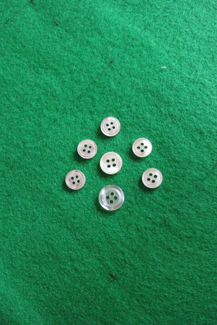 On the top of your felt fabric, in the middle of your 3 inch center, lay out your buttons in the shape of a flower bouquet.