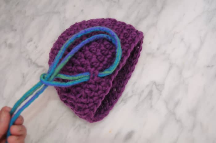 Adding the double sided dreads by inserting them into the holes made by crochet stitches.