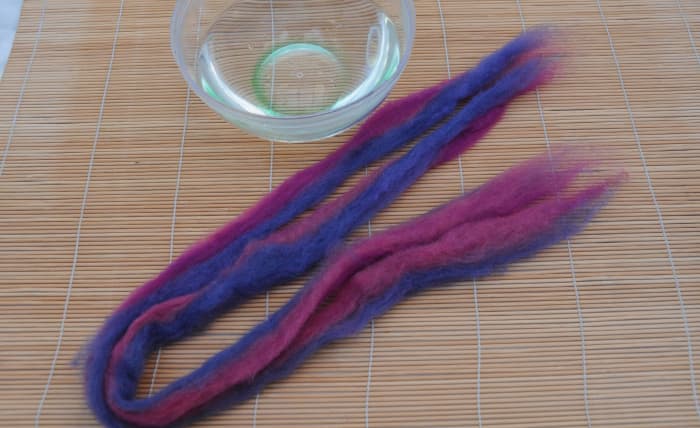 Align the two pieces of pencil roving, wet in hot soapy water and roll. Two ended dread, folded makes two lengths.