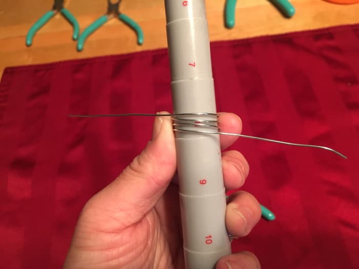 Take your ring mandrel (or marker) and wrap your wire around it so you achieve four total lines of wire.