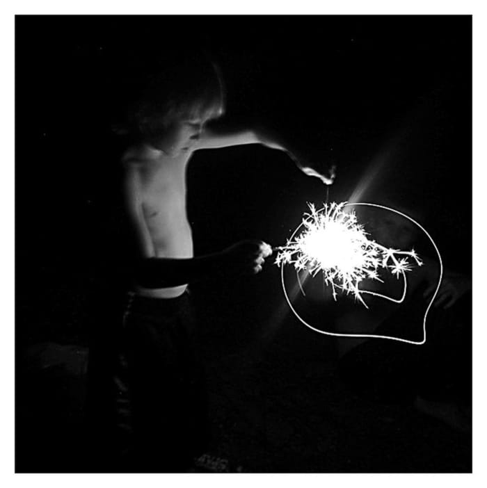 "Firecracker." When I took this photo, I knew my light settings were off and that the lighting was impossible. I kept shooting and later discovered this image. The light opposed to the fading body can be symbolic of childhood and the bright future.