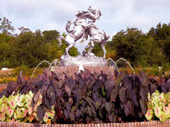 The Fighting Stallions sculpture by Anna Hyatt Huntington stands at the entry to Brookgreen Gardens.