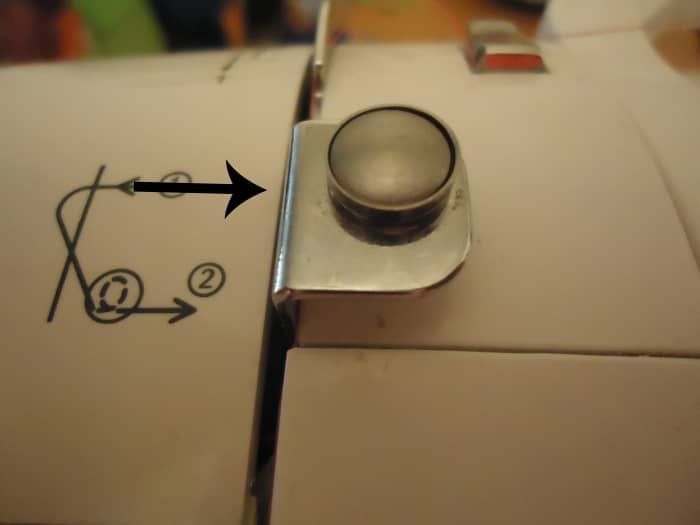 Thread is supposed to run behind this metal part. Apparently, this part is only for winding the bobbin.