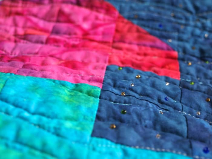 Small seed beads add just the right touch when looking for minimal embellishments. Along with the flowing quilting, these beads were used to add sparkle and movement to the quilt.