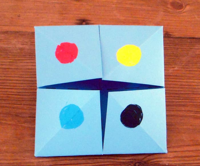 Make a different colored dot on each square flap. (This is the front side of the folded paper.)