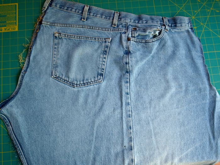 One half of a pair of blue jeans after they have been taken apart. The center seam is the seam that runs down the outside part of the leg.