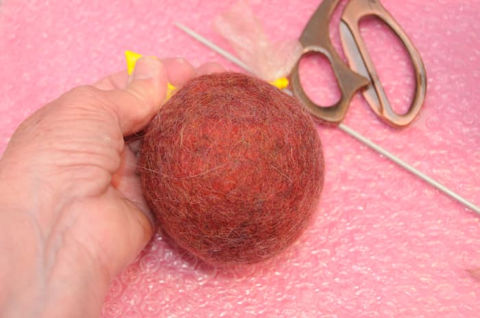Release some of the water and air, knot the balloon and replace it back in the tumble dryer