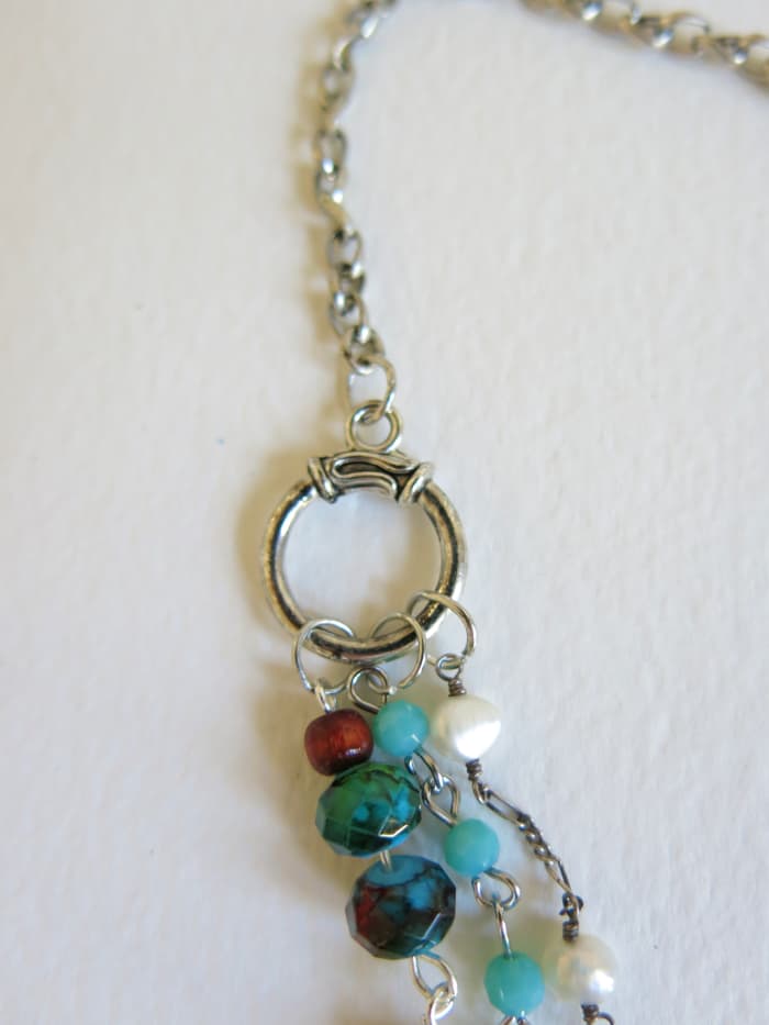 Once you have finished attaching the decorative elements to your layered necklace, it is time to add a neck band.
