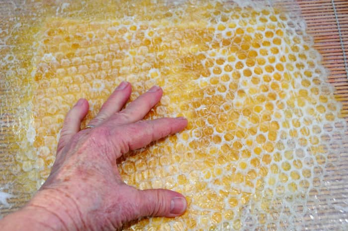 Rub the surface of the bubble wrap using a little hot soapy water to facilitate easy movement.