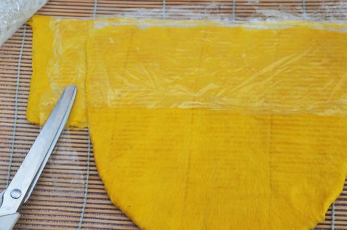 Fold the Pre-felt around the the sides of the hat. Add film to separate the layers and cover with he Pre-felt.