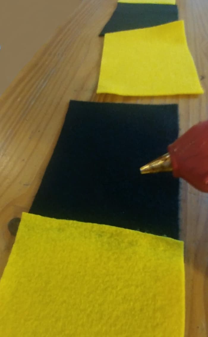 Use a glue gun to apply the glue on the edge of the felt sheets to glue together. It will dry quickly, so be sure to have in place, and press down on sheets with pressure to attach properly.