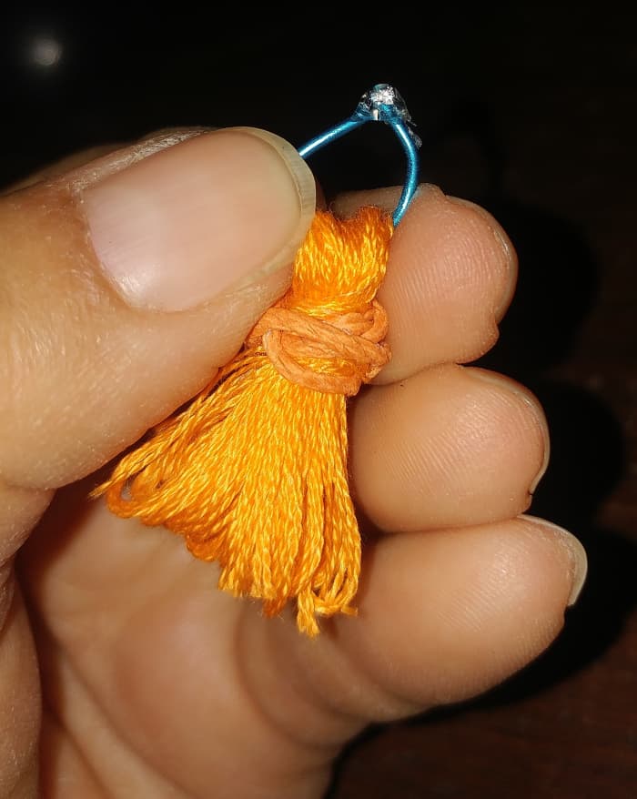 You can simply slip thread through and tie. I used jewelry wire to slip into top of tassel. I hot glued wire together, and turned it inside, to hide glue spot.